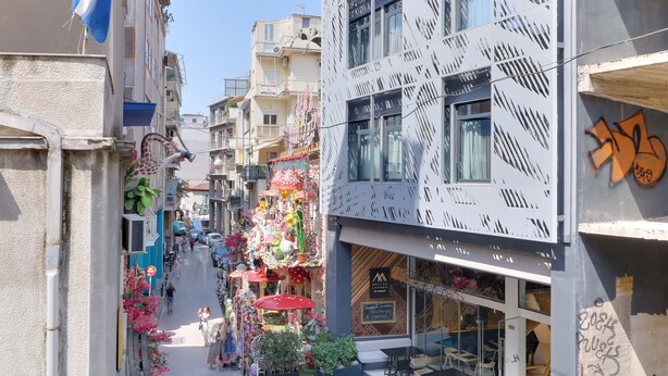 Uma rua estreita, com lojas coloridas e varandas.