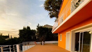 A rooftop terrace with a metal railing, a clear sky, and a view of trees and buildings in the background. - New Orange Villa 6-BR A/C with a Salted Heated Pool & BBQ, Great Mountain View (Cagnes-sur-Mer)