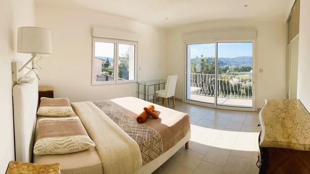 A bedroom with a large bed, a desk, a chair, and a balcony with a view. - New Orange Villa 6-BR A/C with a Salted Heated Pool & BBQ, Great Mountain View (Cagnes-sur-Mer)
