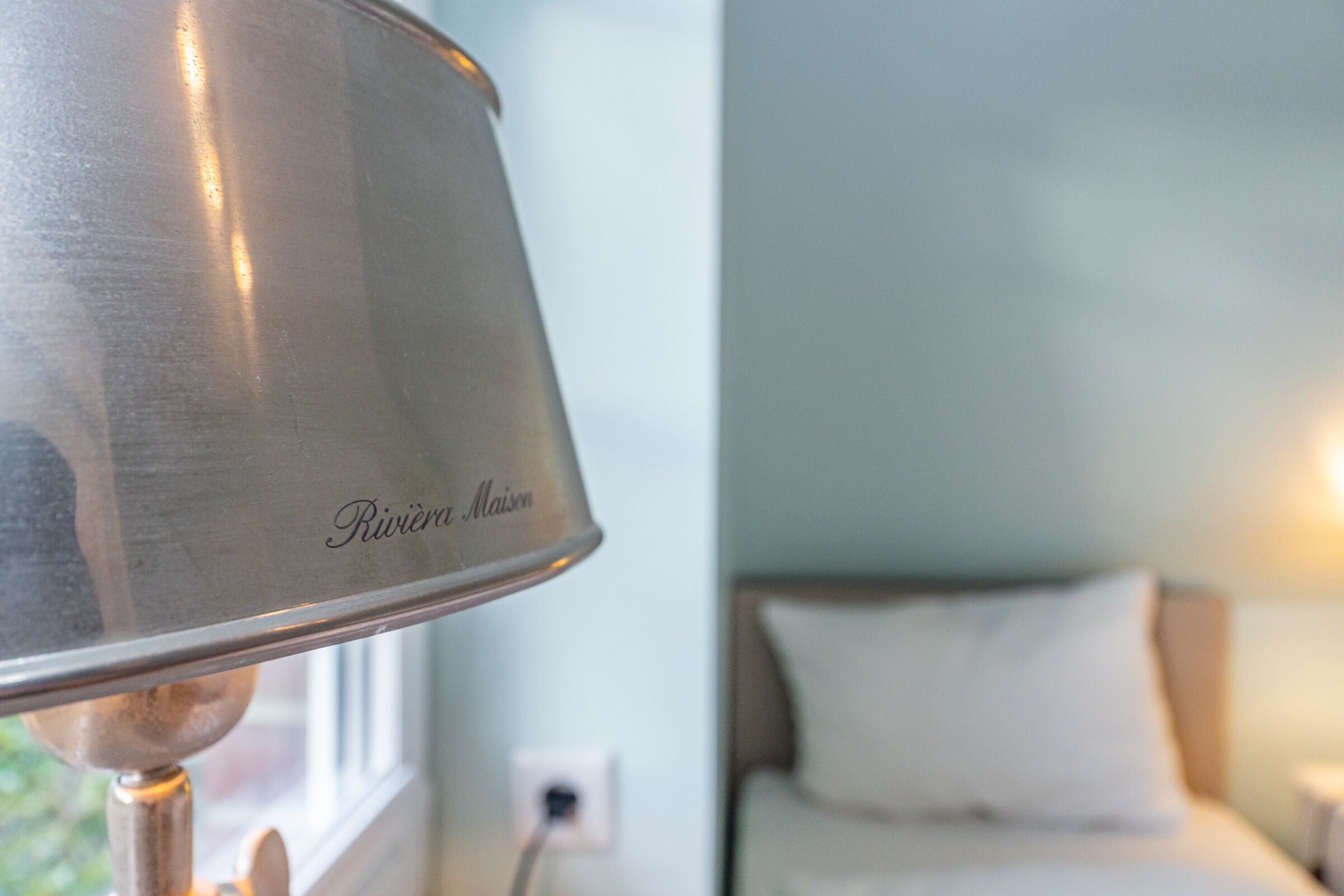Nærbillede af en lampe med mærket 'Riviere Maison' på foden.