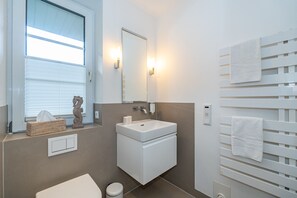 Bathroom features a pedestal sink, mirror, towel rack, and toilet.