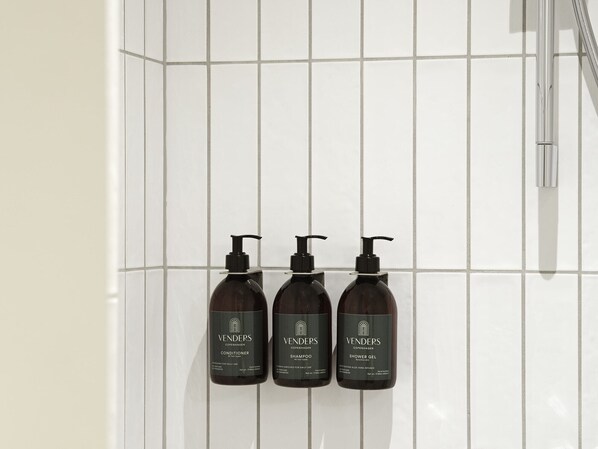 Trois bouteilles de produits Venders Copenhagen sont posées sur un mur recouvert de carreaux.