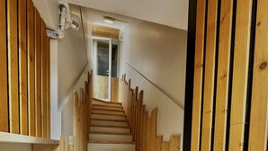 Unes escales de fusta amb barana, que condueixen a una porta a dalt.