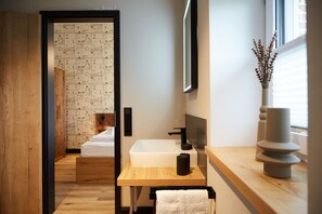 Une salle de bain moderne avec un meuble-lavabo en bois, un lavabo blanc et un miroir.