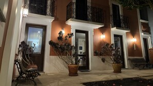 Un edificio con varios balcones, macetas y un banco.