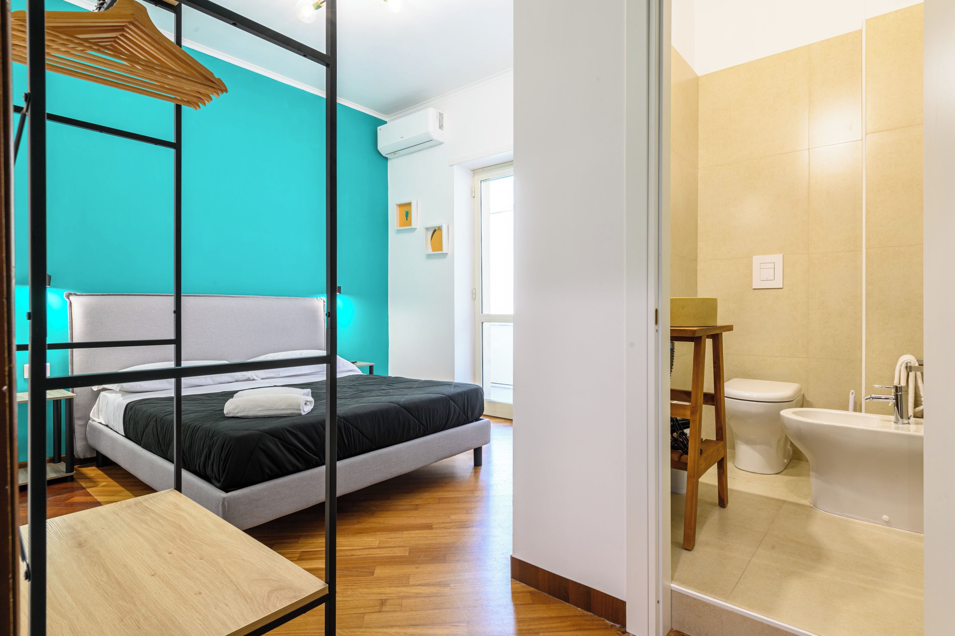 Une chambre d’hôtel moderne, équipée d’un lit, d’une table en bois et d’une salle de bain avec des toilettes et une baignoire.