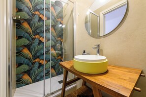 Habitación cuádruple Deluxe | Baño | Ducha y cabezal de ducha tipo lluvia