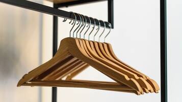 A wooden hanger rack with multiple hangers, mounted on a metal frame.