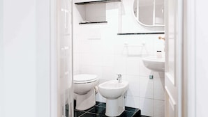 Ein modernes Badezimmer mit Toilette, Bidet und Waschbecken.