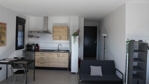 A compact living space with a kitchenette, a sofa, and a dining area. - Relax al pie de la Alfaguara , Ideal Para Escalada, Senderismo y Gastronomía (Fuente Grande)