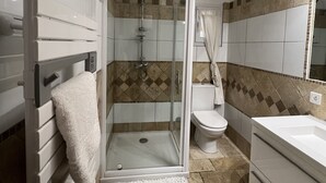 Un baño con ducha de vidrio, inodoro y bañera.