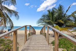 Guests can walk down the staircase to the public beach, flanked by palm trees and overlooking the ocean.