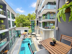 Un bâtiment moderne doté d’une piscine à débordement, d’un espace extérieur aménagé et de verdure.