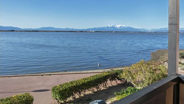 A view of a lake with a mountain range in the background.