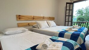 A hotel room with two beds, each with a blue and white quilt, white bedding, and a wooden headboard. - Villa Rural (Campos do Jordão)