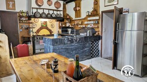 A kitchen with a marble island, stainless steel refrigerator, and various kitchen utensils and appliances. - Charming Country Retreat: Sleeps 11, Indoor Pool, Pet-Friendly, Near Château-Gontier (Gennes-Longuefuye)