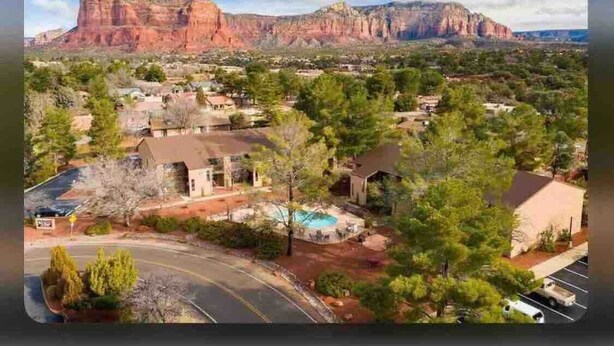 A residential area with houses, a swimming pool, and a mountain in the background.