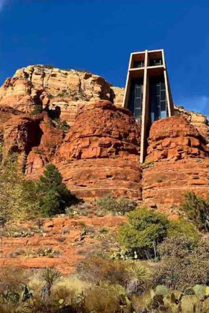 A building with a unique architectural design, situated on a red rock formation.