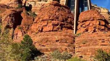 A building with a unique architectural design, situated on a red rock formation.