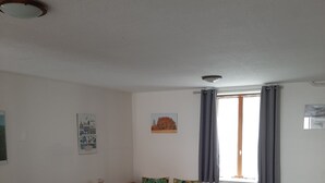 A living room with a sofa, a coffee table, and a dining area with chairs. - Gîte de Kerezenn (Fougerolles-Saint-Valbert)