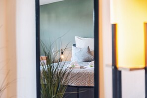 A bedroom with a bed, pillows, and a bedside table with a lamp. - Nature Apartments - 100 qm, Zentral, 7 Pers (Erfurt)