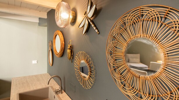 Un baño con lavamanos, espejo y decoración en la pared, incluyendo una estrella de mar y diseños circulares.