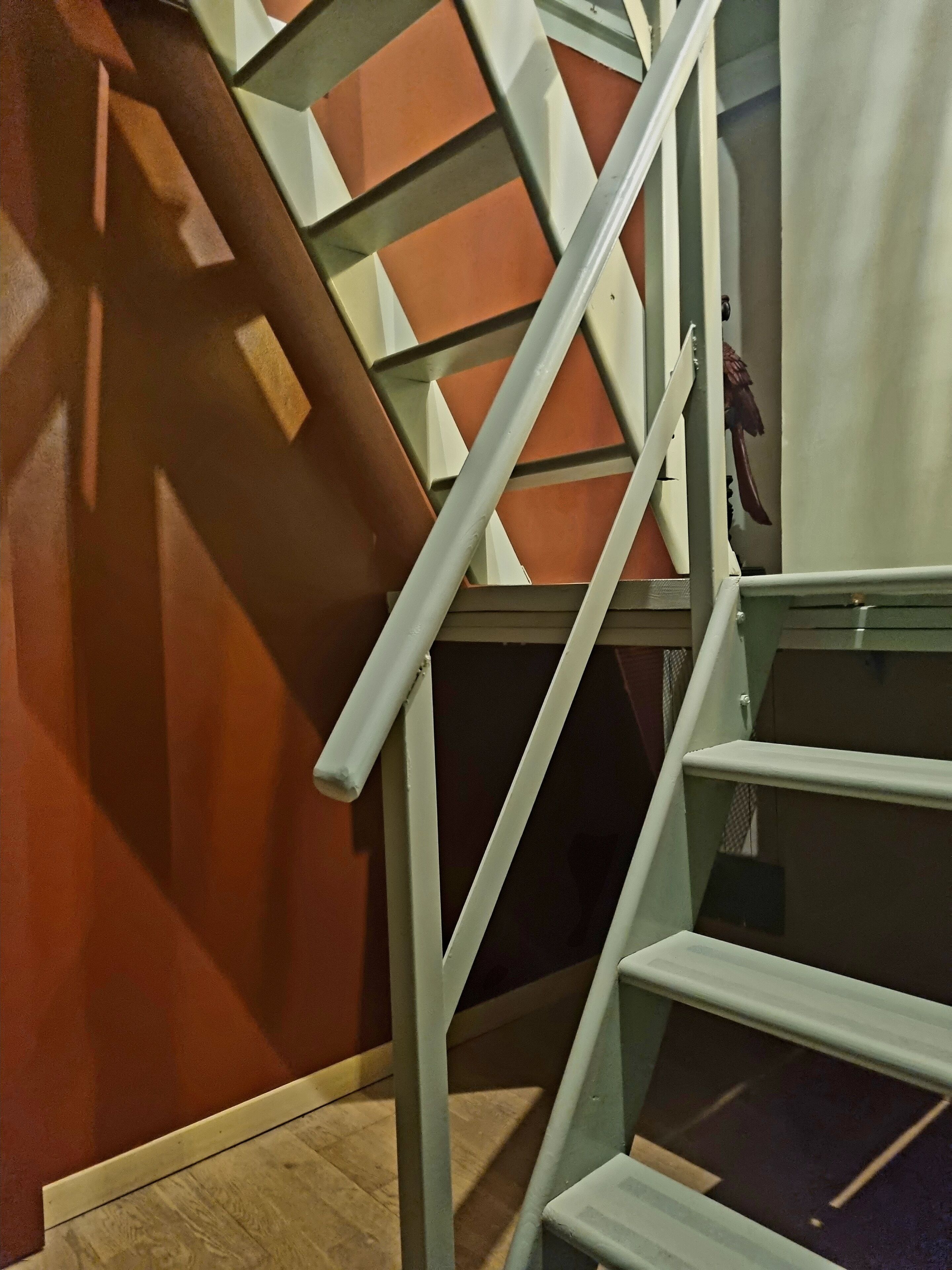 A staircase with metal railings and a wooden floor.