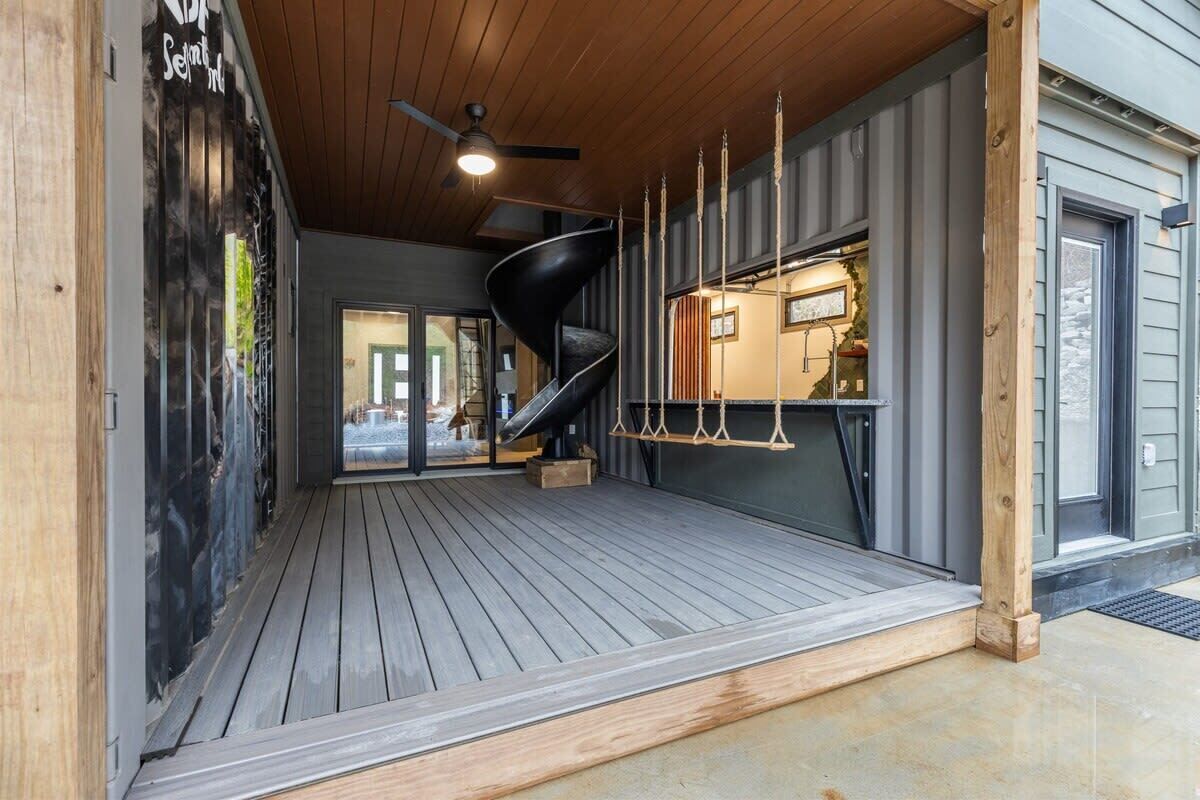 A modern interior with a spiral staircase, wooden flooring, and a ceiling fan.