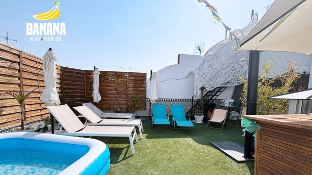 Uma área de piscina com espreguiçadeiras, uma piscina insuflável pequena e um deck de madeira.