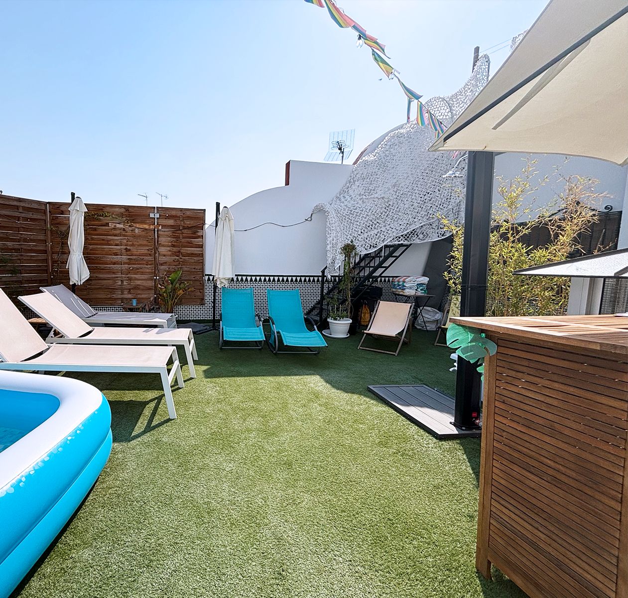 A pool area with lounge chairs, a small inflatable pool, and a wooden deck.