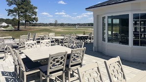 An outdoor patio with tables and chairs, a covered seating area, and a view of a golf course. - Kelly's Cozy Golf Getaway/ Enclosed Patio/ Lakeside/Woodlake's Maples Golf Course on Site/Minutes from Fort Bragg/40 Plus Golf Courses Nearby/Sleeps 8 (Vass)