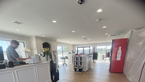 A spacious room with a reception desk, a Coca-Cola refrigerator, and a large window. - Kelly's Cozy Golf Getaway/ Enclosed Patio/ Lakeside/Woodlake's Maples Golf Course on Site/Minutes from Fort Bragg/40 Plus Golf Courses Nearby/Sleeps 8 (Vass)