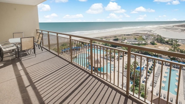 A balcony with a view of a beach and a pool area. - Luxurious Oceanfront 2 Bdrm Condo Stunning Views (North Myrtle Beach)