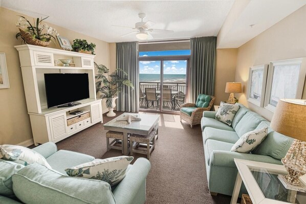Relax in a comfortable seating area with a sofa, armchair, and flat-screen TV.