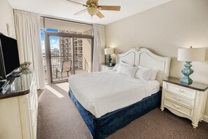 Relax in this inviting room with a large bed, flat-screen TV, and sliding glass door leading to a balcony with a view.