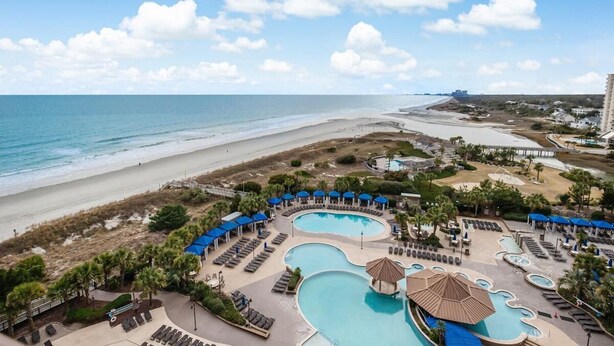 A resort with multiple swimming pools, beach access, and a view of the ocean.
