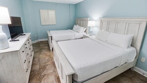 A bedroom with two beds, a dresser, and a window with blinds. - Relax in Style: Oceanfront 3 Bedroom Condo (North Myrtle Beach)