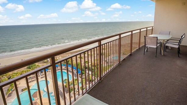 Un balcon avec vue sur la plage et sur l’espace piscine.