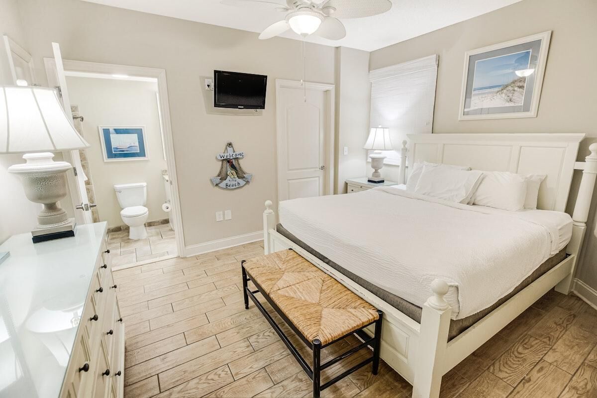 Une chambre à coucher avec un lit, une table de chevet et un banc.