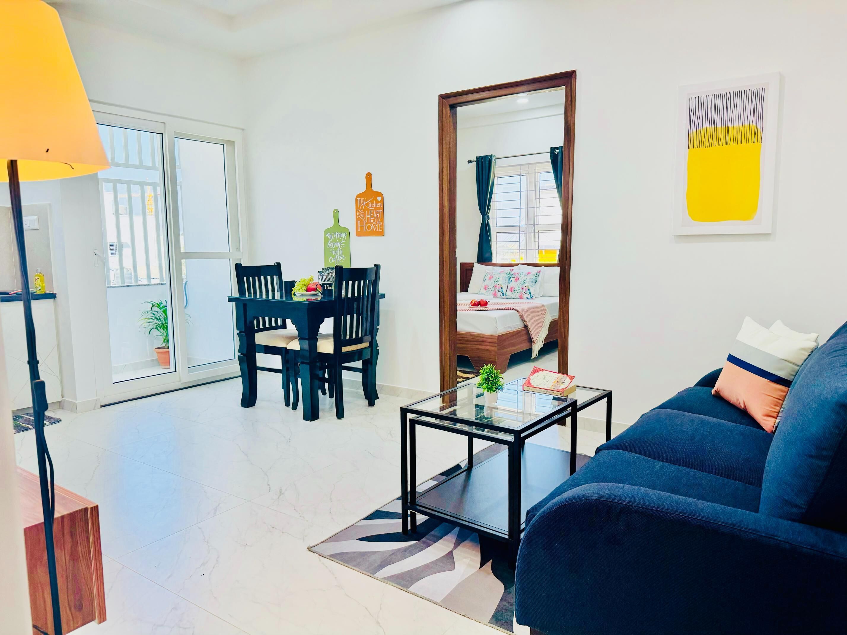 Una sala moderna con sofá, una mesa de centro de vidrio y un comedor con sillas y una mesa.