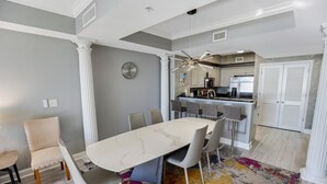 A dining area with a marble table, white chairs, and a colorful rug. - 3 Bedroom Condo with King and Queen Sized Beds (North Myrtle Beach)