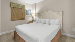 A neatly made bed in a room with a headboard, a nightstand with a lamp, and a wall-mounted artwork. - Relax and Unwind in this Oceanfront 1 Bdrm Condo (North Myrtle Beach)