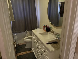 Bathroom features a sink, toilet, shower, and towel rack.