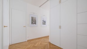 Un pasillo con puertas blancas y suelo de madera.