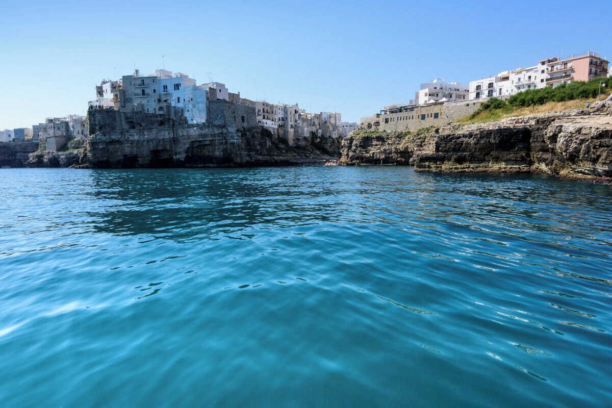 A coastal town with buildings built on rocky cliffs overlooking the sea.
