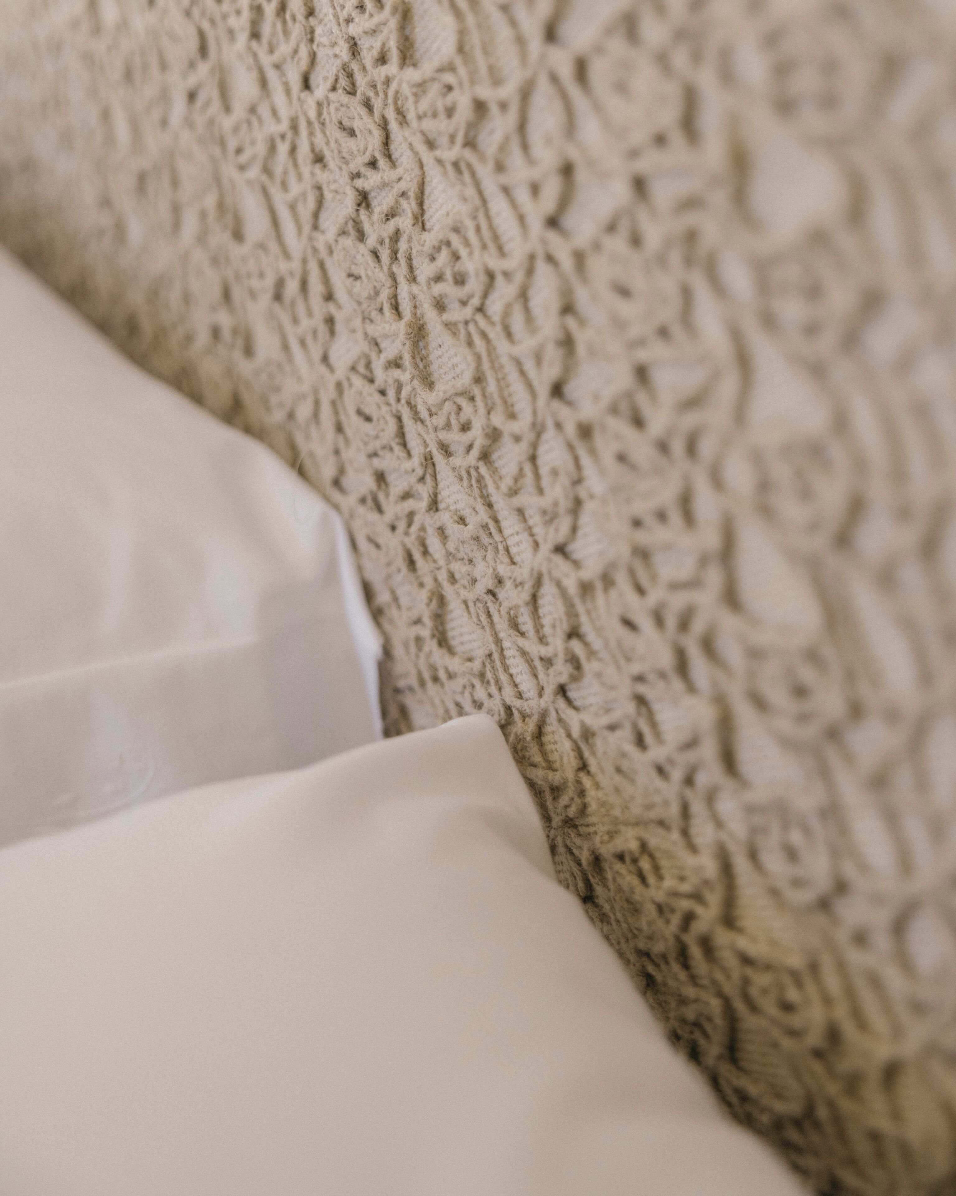 A close-up of a textured fabric, likely part of a bed or couch.