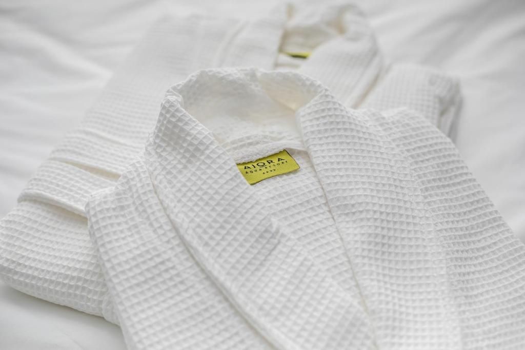 A neatly folded white garment with a tag.