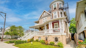 A two-story house with a wrap-around porch, a turret, and a front staircase. - Centrally Located Ocean City Apt < 1 Mi to Beaches (Ocean City)