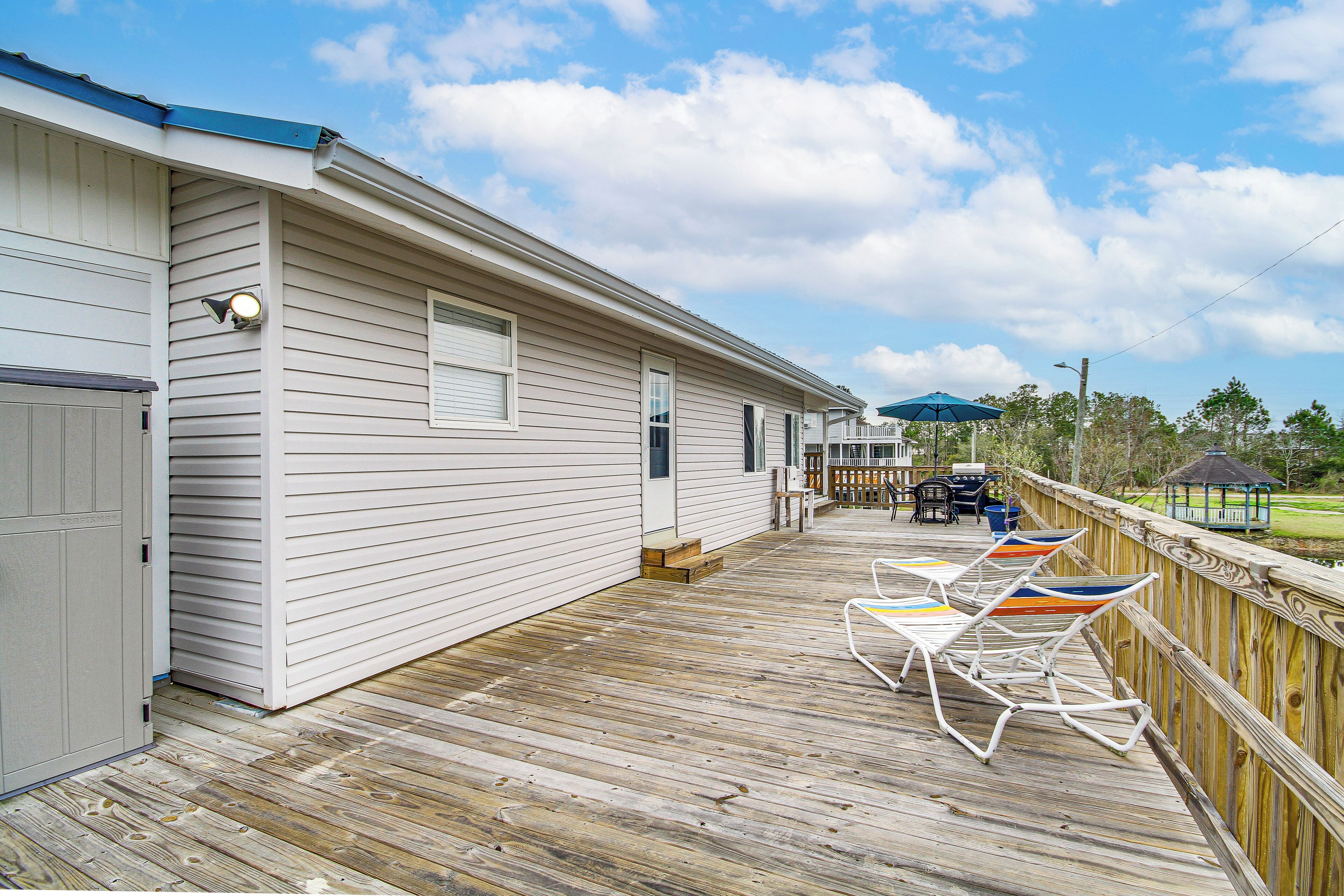 Une terrasse en bois, agrémentée de mobilier d’extérieur, avec un gazebo en arrière-plan.