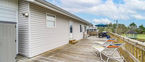 Une terrasse en bois, agrémentée de mobilier d’extérieur, avec un gazebo en arrière-plan.